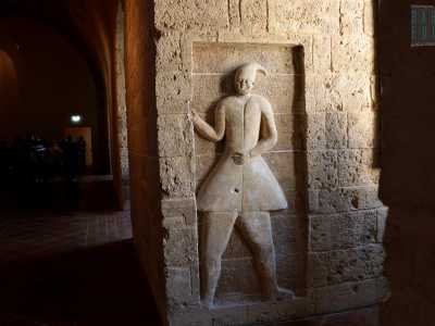 ...con ai due lati rilievi cinquecenteschi di alte figure di eunuchi mori reggicortina